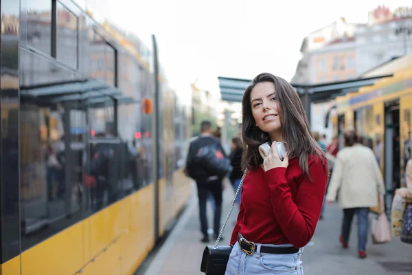 Kulaklıklarla Tramvay Için Bekleyen Genç Esmer Kadın — Stok fotoğraf