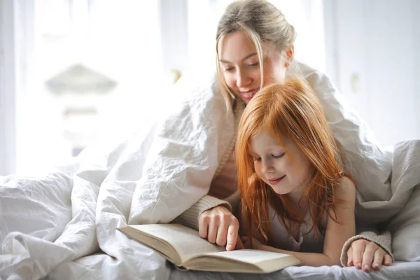 Mère Fille Couchées Lit Pointant Sur Une Photo Dans Livre — Photo