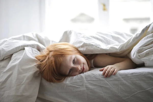 Μικρό Κορίτσι Κοκκινομάλλα Ξαπλωμένη Στο Κρεβάτι Κάτω Από Την Κουβέρτα — Φωτογραφία Αρχείου