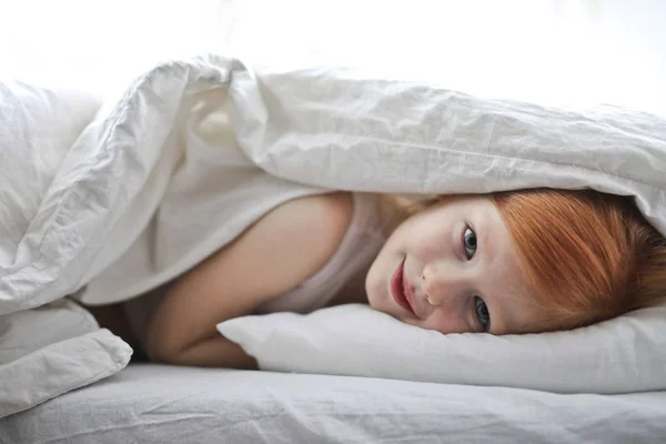 躺在毯子下的红头发的小女孩 — 图库照片
