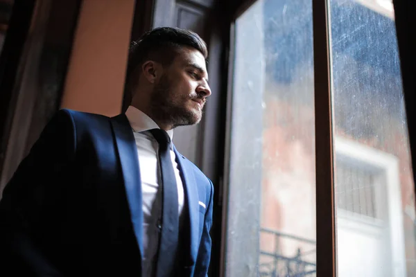 Νεαρός Επιχειρηματίας Στο Κοστούμι Κοιτάζοντας Έξω Από Παράθυρο — Φωτογραφία Αρχείου