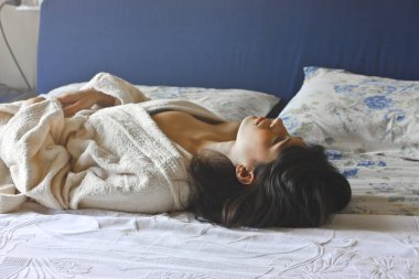 Bir kız yatakta yatıyor.