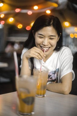 Gülümseyen kız gece içiyor.