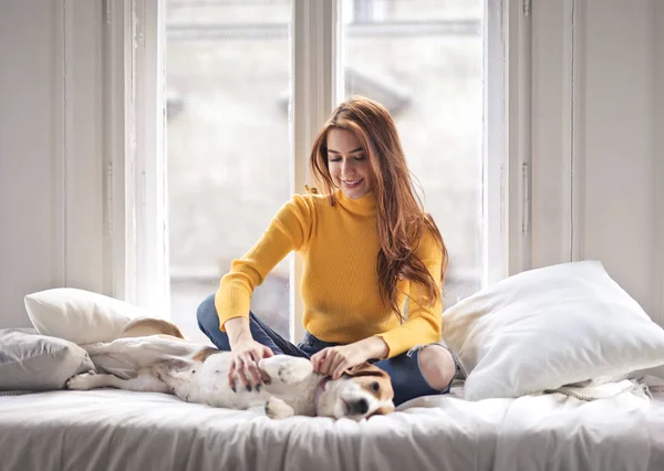 Lächelndes Mädchen Mit Ihrem Hund Auf Dem Bett — Stockfoto