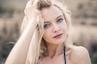 Kumsalda sarışın bir kızın portresi.