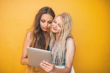 İki arkadaş I-pad 'i izliyor.