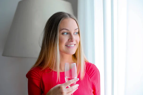 Blond Flicka Dricker Vin Nära Fönstret — Stockfoto