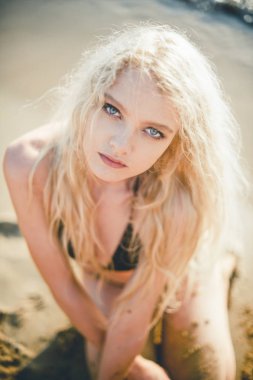 Kumsalda sarışın bir kızın portresi.