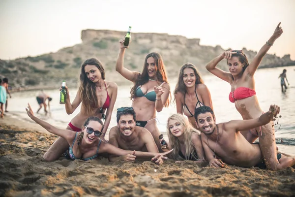 A group of friends have a funny moment on the beach