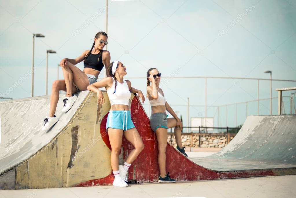 Three fit girls in a skate park
