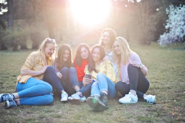 Bir grup kız parkta selfie çekiyor