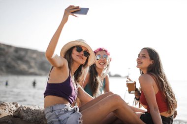 Kızlar sahilde selfie çekiyor