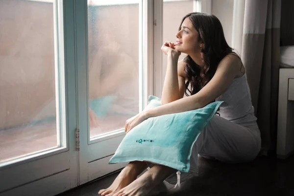 Ein Mädchen Blickt Mit Einem Kissen Aus Dem Fenster — Stockfoto
