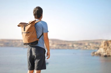 Bir adam denize bakıyor.