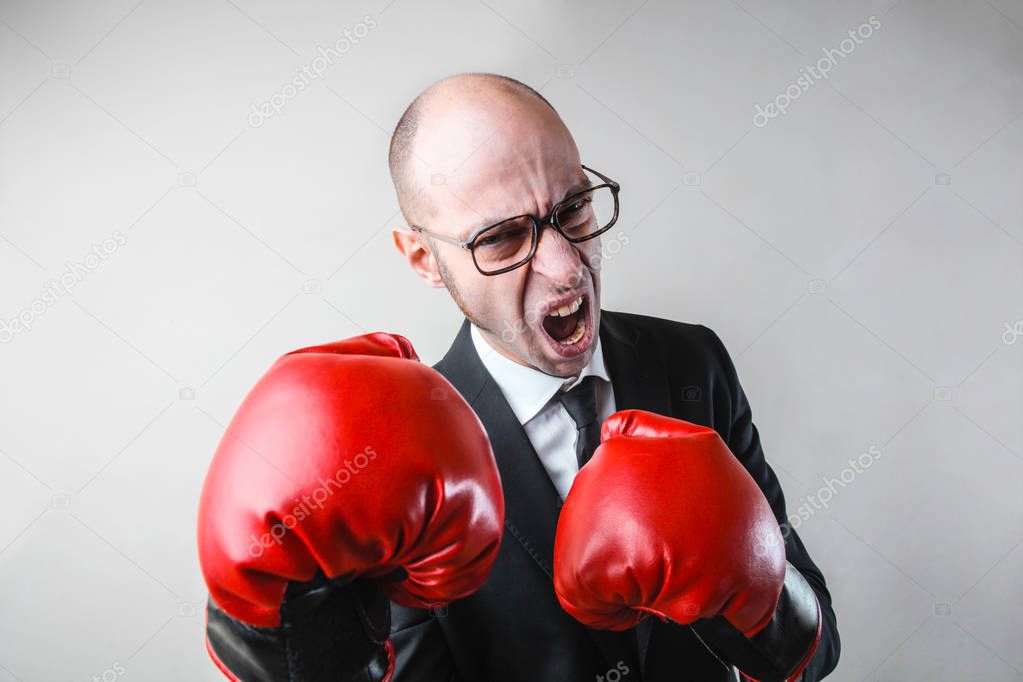 An angry businessman with gloves for boxing