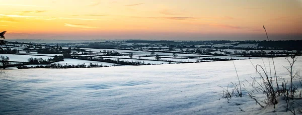 Sunrise over a snow covered landscape, in Brinkworth, Wiltshire