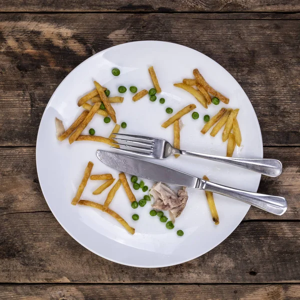 チップの豆と鶏の残り物 ナイフとフォークを素朴な木製の背景の上にプレートを — ストック写真