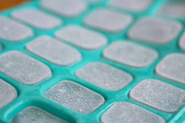 Cubos de gelo em molde de silicone verde — Fotografia de Stock