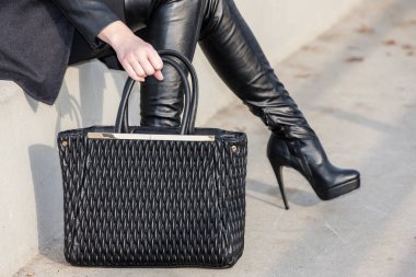 El çantalı şık siyah çizmeler.