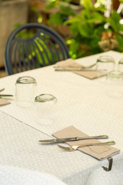 Çatal bıçak ve bardaklar Assisi, Umbria, İtalya 'da bir açık hava restoranında bir masaya yerleştirilmiş. Hoş bir ortam yaratıyor.