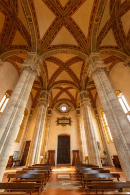 Pienza Duomo 'sunda sunağa bakan boş banklar, İtalya, Toskana' daki sütunları ve tavanı gösteriyor.