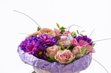 İçinde güller, kasımpatılar, gerberalar ve orkideler bulunan canlı bir buket, büyüleyici bir çiçek aranjmanı yaratıyor.