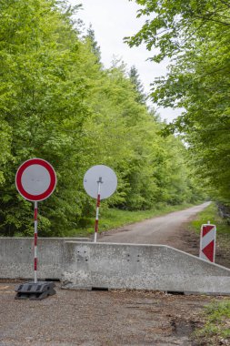 Çek Cumhuriyeti 'nin Nova Lhota kentindeki bir orman yoluna erişimi engelleyen beton barikat ve trafik işaretleri yasak bölge yaratıyor.