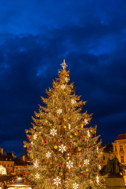 Illuminated Christmas tree with golden ornaments and lights in Prague Old Town Square at night