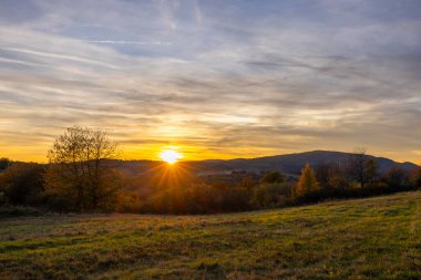 Güney Slovakya 'da Budina yakınlarındaki kırsal tepelerin üzerinde sıcak gün batımı ışığı