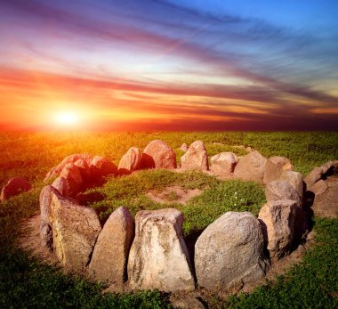 çim günbatımı arka plan üzerinde taş daire