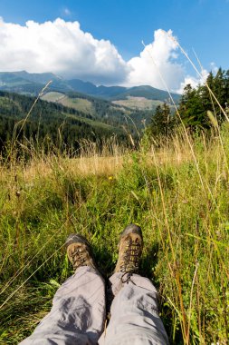 Uzun yürüyüşe çıkan kimse'nın botlarının içinde dağ çayır çim