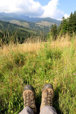 yürüyüşçüler çizmeler dağlarında çayır üzerinde