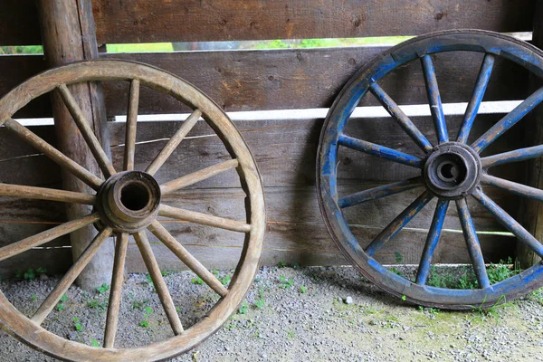 Zwei Alte Holzräder Auf Hölzernem Wandhintergrund — Stockfoto