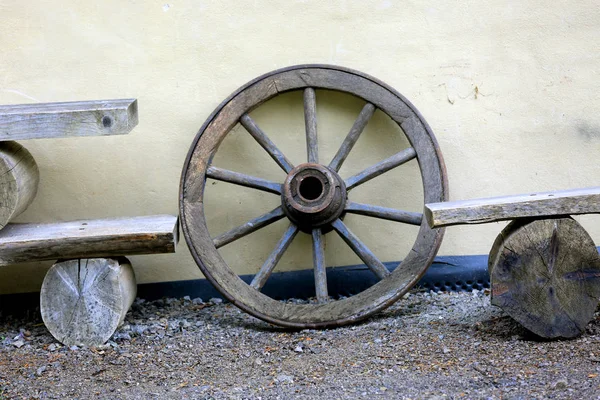 黄色の壁の背景に古い木製の車輪 — ストック写真