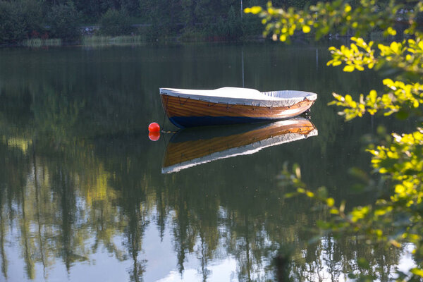 Alone wooden boat on lake in morning time