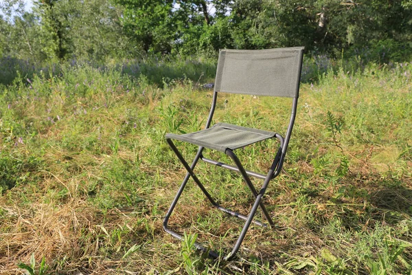 Folding tourist chair on meadow — Stock Photo, Image