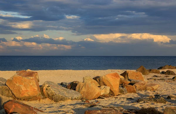 Камни на морском песчаном пляже в вечернем свете — стоковое фото