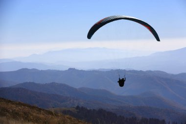 dağlarda vadi üzerinde uçan yamaç paraşütü