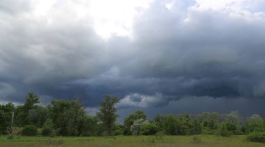 dark clouds in thunderstorm sky in steppe clipart