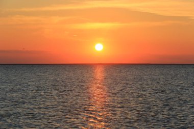 Göl yüzeyinde kırmızı gün batımı