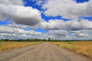 Gökyüzündeki güzel bulutların altında eski kırsal yol manzarası
