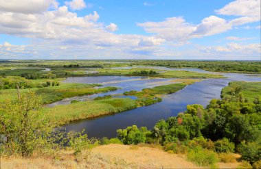 Tepeden delta nehrinin manzarası gökyüzündeki güzel bulutların altında. Ukrayna, Vorskla Nehri