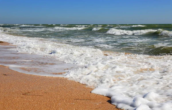 夏の嵐で黄色の砂浜の海岸に白い泡 — ストック写真