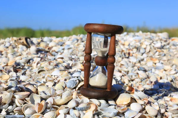 Alte Sanduhr Auf Muscheln Meer Unter Blauem Himmel — Stockfoto