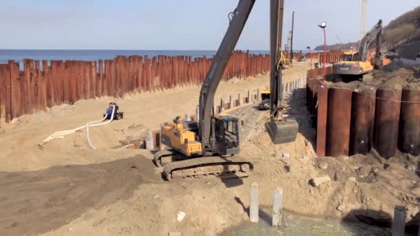 Baltık Denizi kıyı şeridi güçlendirilmesi sahil üzerinde Ekskavatör inşaat — Stok video