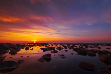 Güzel gün batımı taşlarla deniz yan