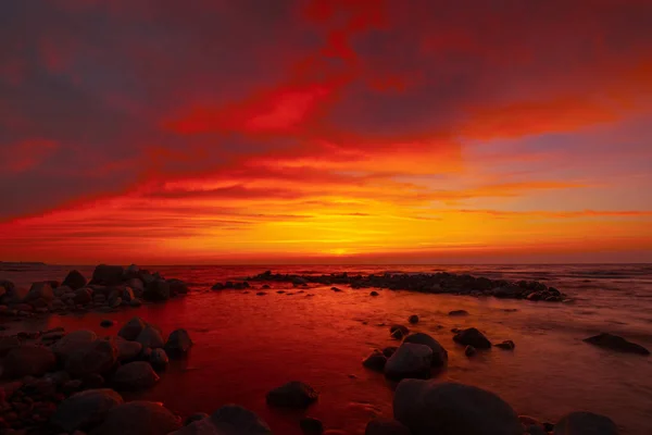 Pôr do sol bonito no lado do mar com pedras — Fotografia de Stock