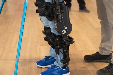 Demonstration of powered exoskeleton for disabled persons clipart