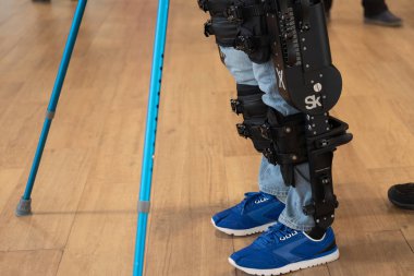 Demonstration of powered exoskeleton for disabled persons clipart