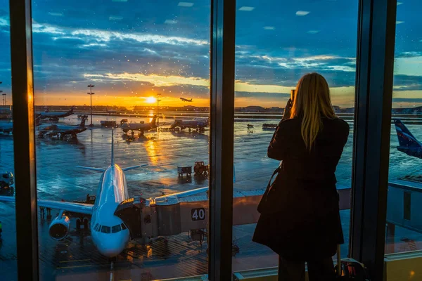 Mujer Está Pie Junto Ventana Aeropuerto Fondo Del Atardecer —  Fotos de Stock